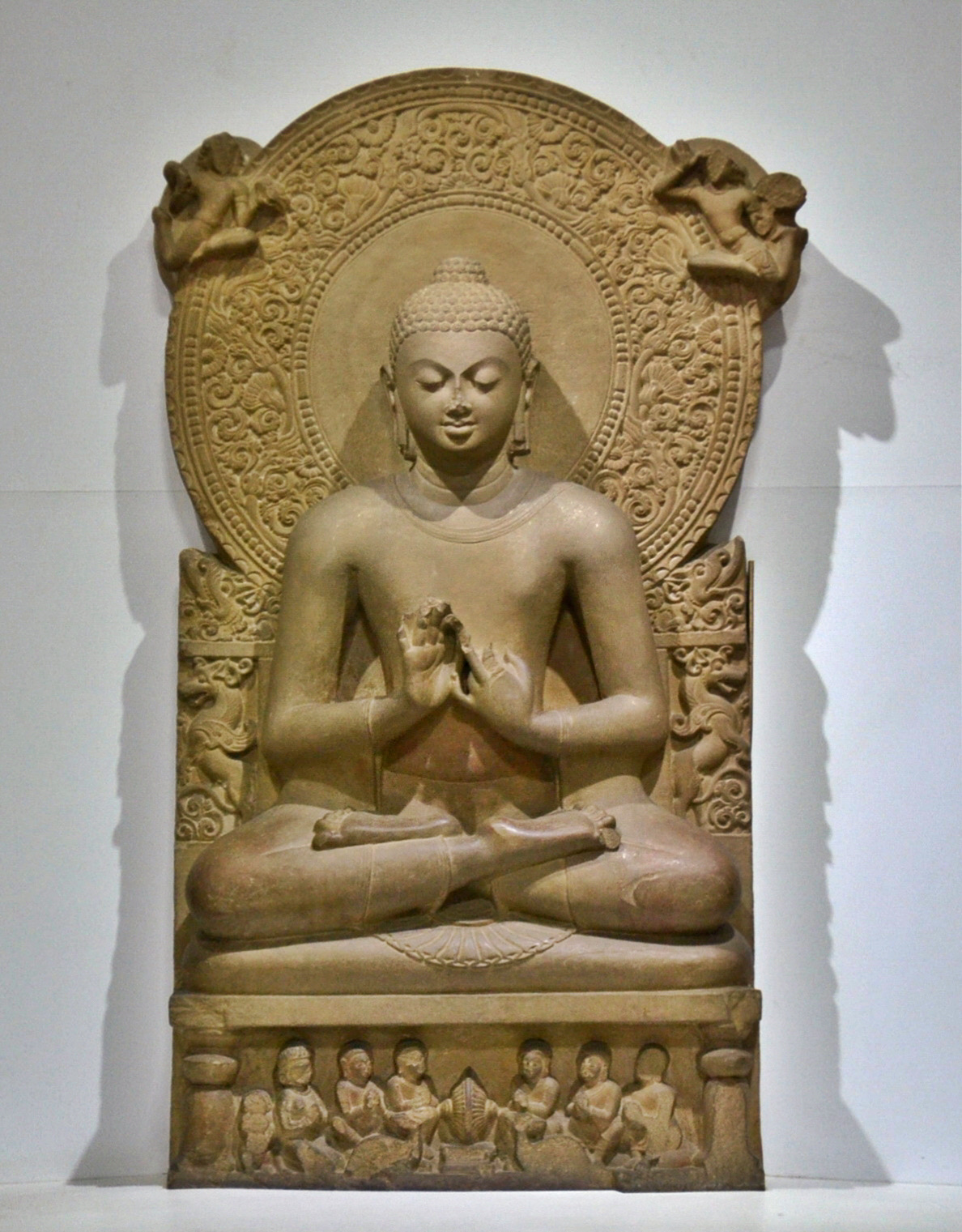 A seated Buddha in the teaching gesture (dharmachakra mudra), about 475 CE, found at Sarnath and kept in the Sarnath Museum. It refers to the Buddha's first sermon at Sarnath.